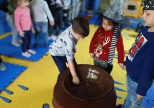 dzieci wrzucają monety do miski z wodą